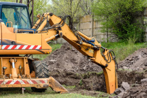 yellow excavator on a construction site against blue sky. the modern excavator performs excavation work on the construction site